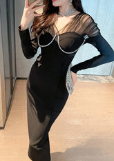 Close-up of the sheer mesh and pearl detail on the structured bodice of the black midi dress.